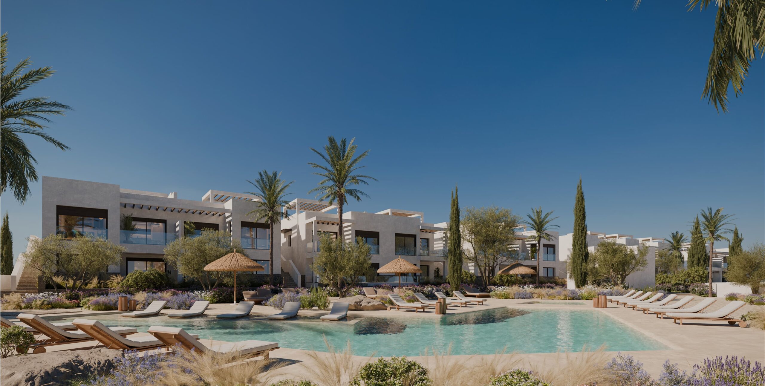 Resort pool area with lounge chairs, planters, and modern white buildings under a clear blue sky.