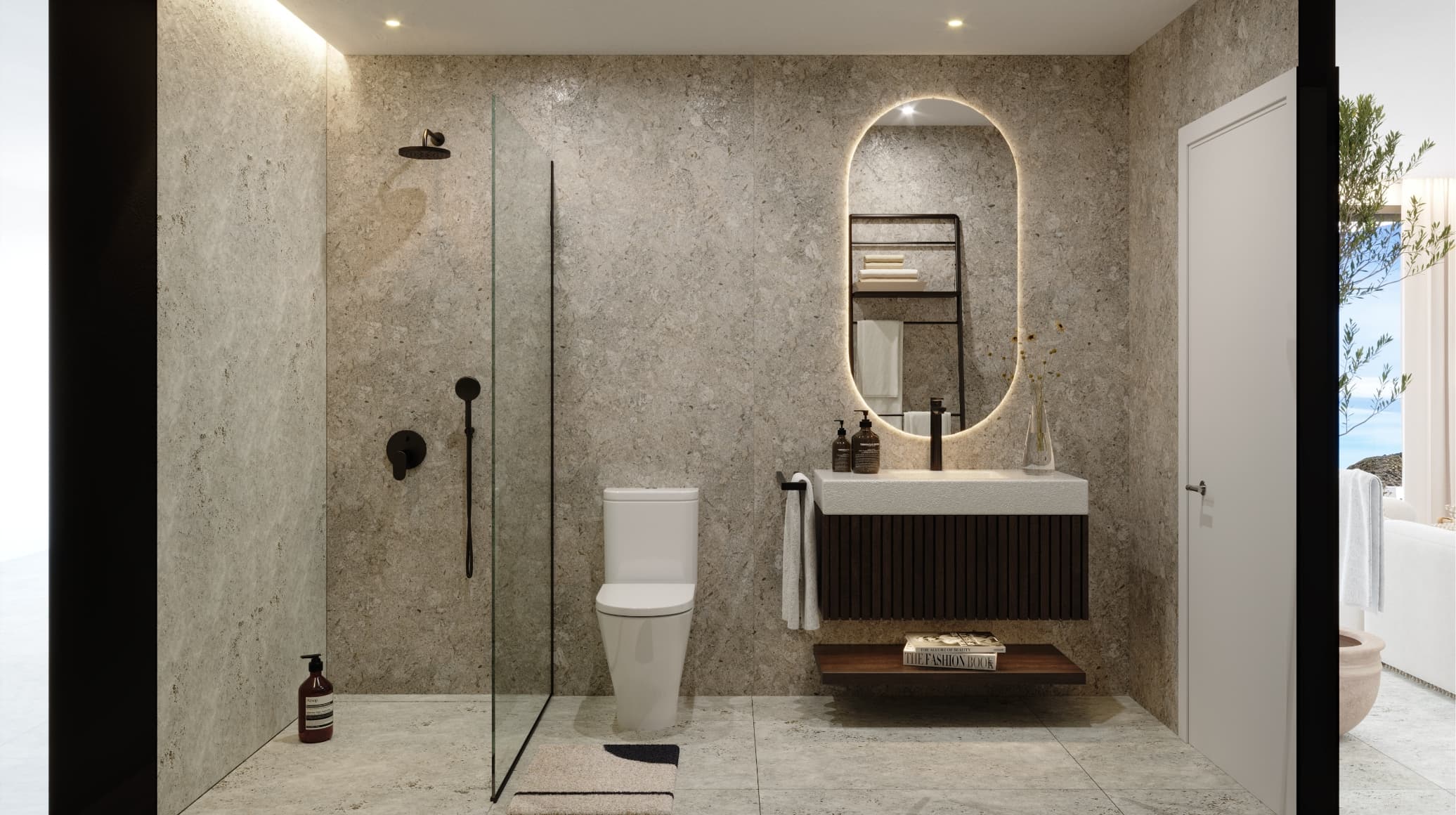 Contemporaneo_bano-1 - MiraCasa Modern bathroom with beige stone walls, glass shower, oval backlit mirror, dark wood vanity, towels, and a toilet.