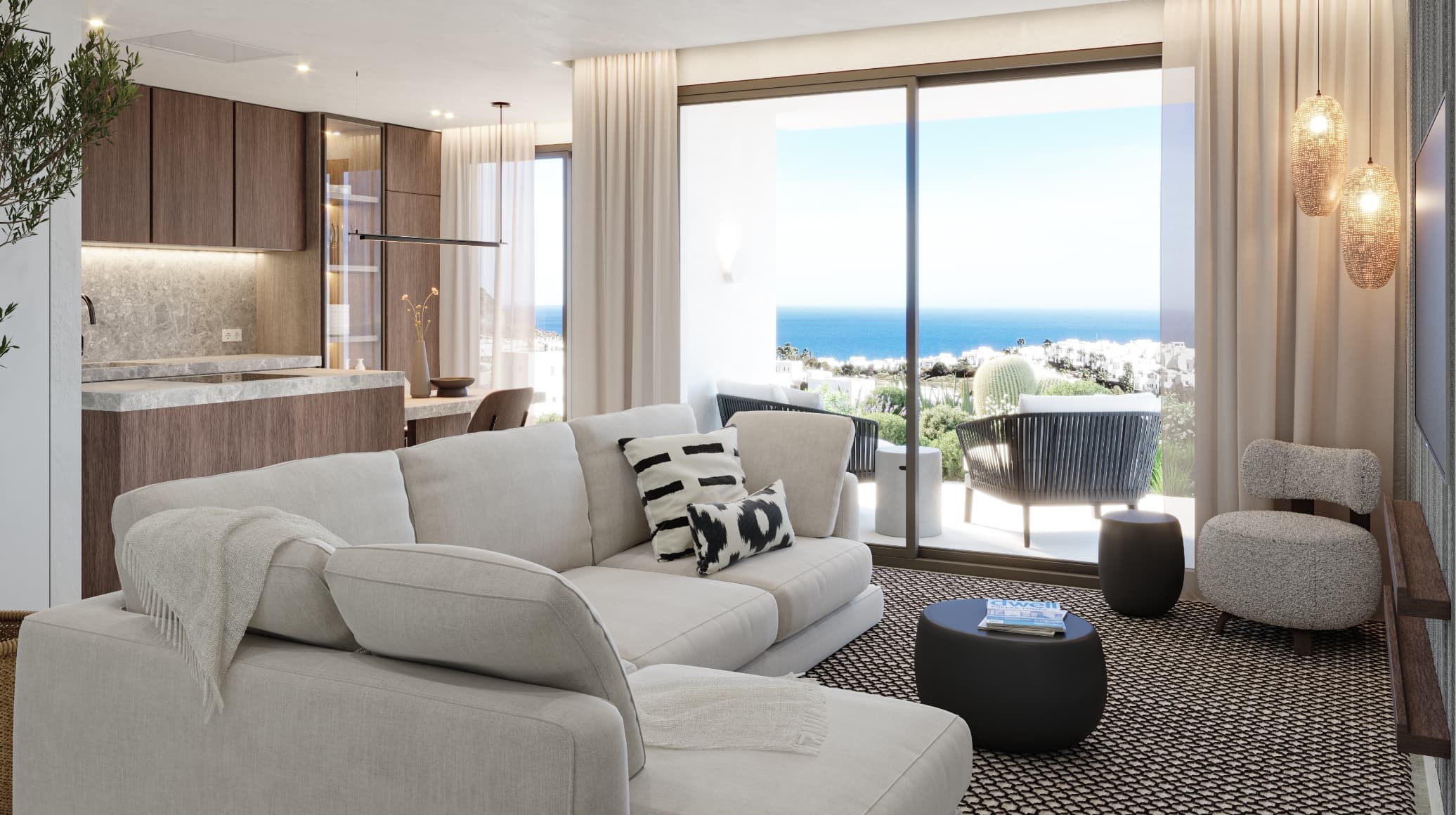 Open-plan coastal living room with a light gray sectional, throw blanket, and black-and-white pillows, opening to a balcony with an ocean view.