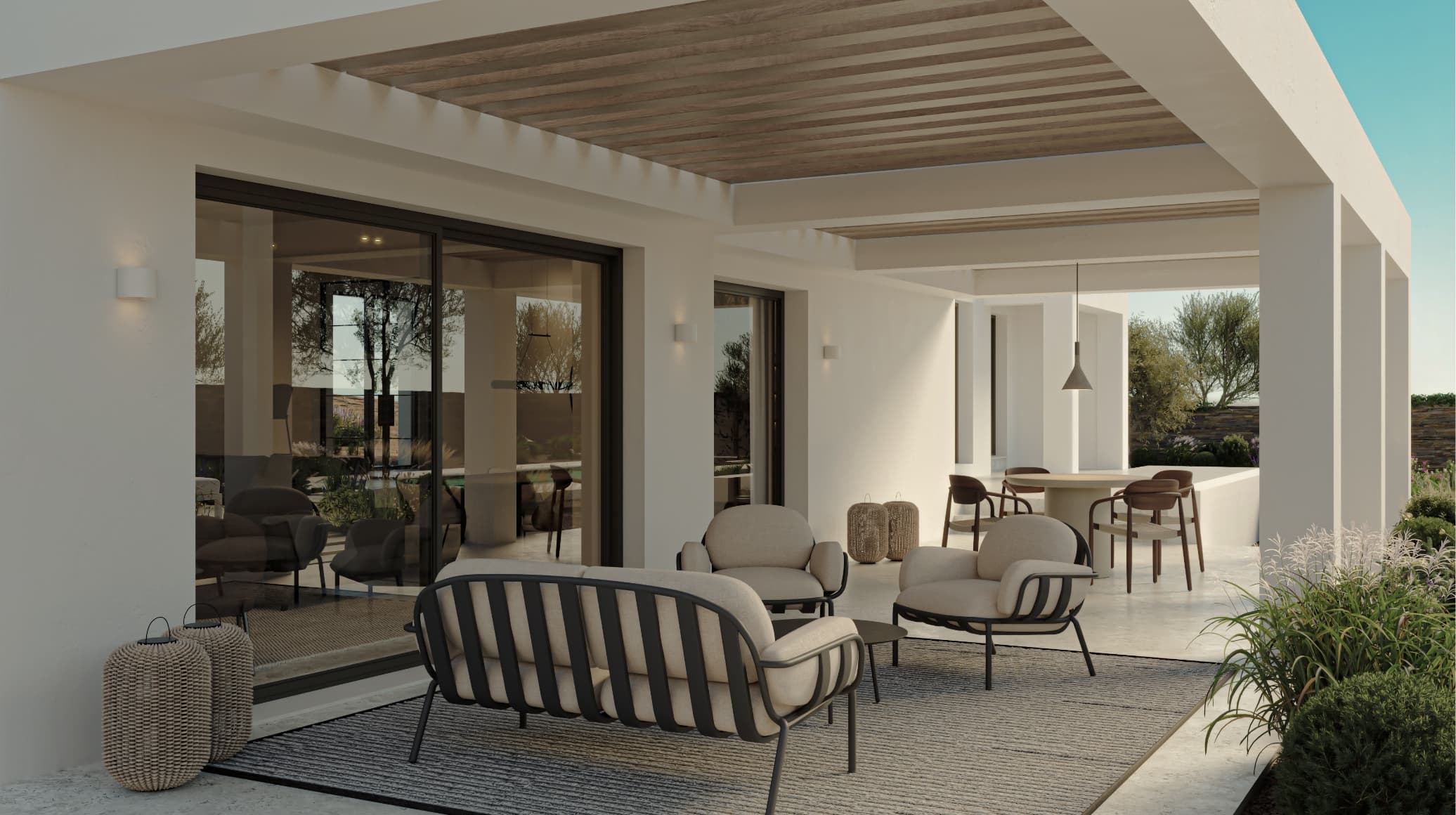 Contemporaneo_terraza - MiraCasa Modern outdoor patio with cream cushioned seating, wicker lanterns, and a pergola under a bright blue sky.