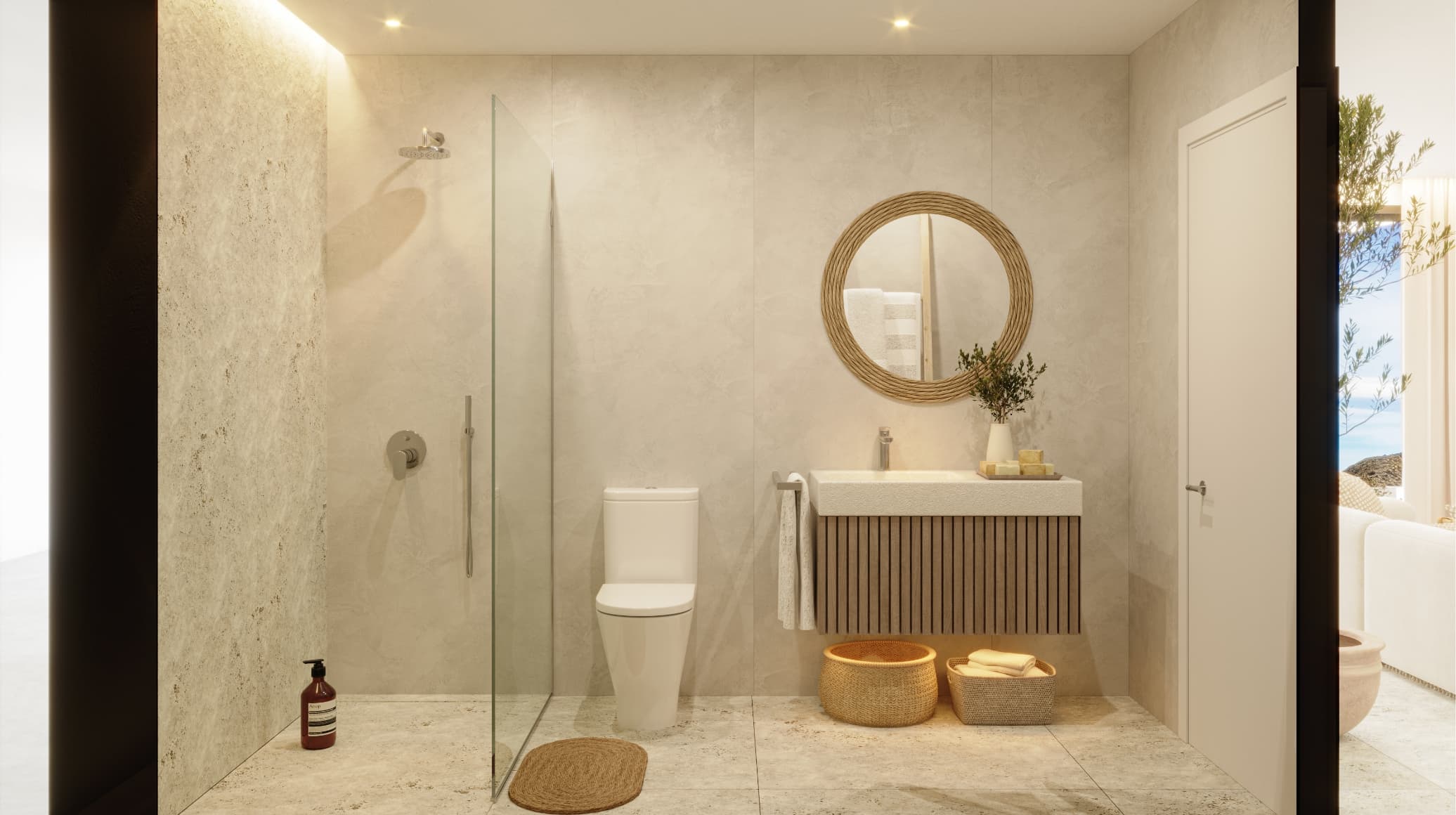 Mediterraneo_bano-2 - MiraCasa Modern bathroom with glass shower, white toilet, and a circular woven-mrope mirror above a wood-grain vanity with towels and plants on top