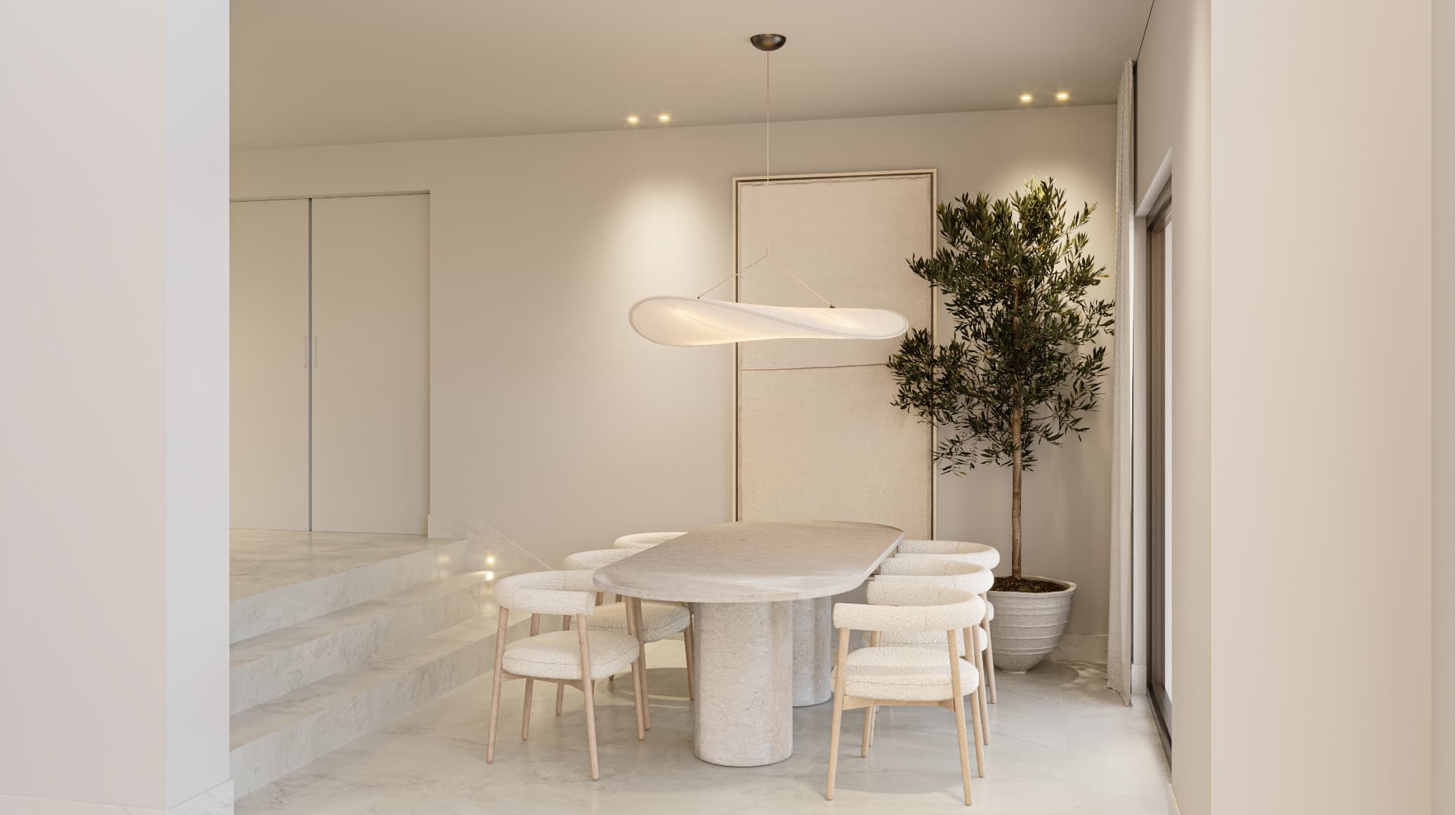 Natural_comedor - MiraCasa Bright minimalist dining area featuring a round marble table with six woven stools, a sculptural pendant light, and a tall potted tree against neutral walls.